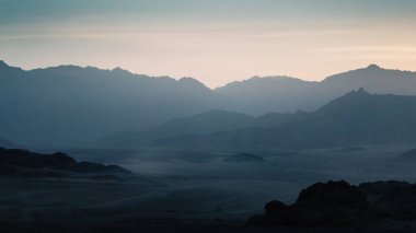 Gece çöl manzarası kayalık dağlar ve günbatımı gökyüzü Sharm El Sheikh Mısır 'da bulutlar