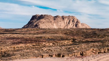 Mavi gökyüzü ve beyaz bulutlar karşı çölde yüksek dağ