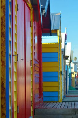 Brighton Beach, Victoria, Avustralya 'daki ikonik plaj kulübeleri. Ahşap panellerin renkleri kırmızı, mavi ve sarıdır. Gökyüzü mavi.