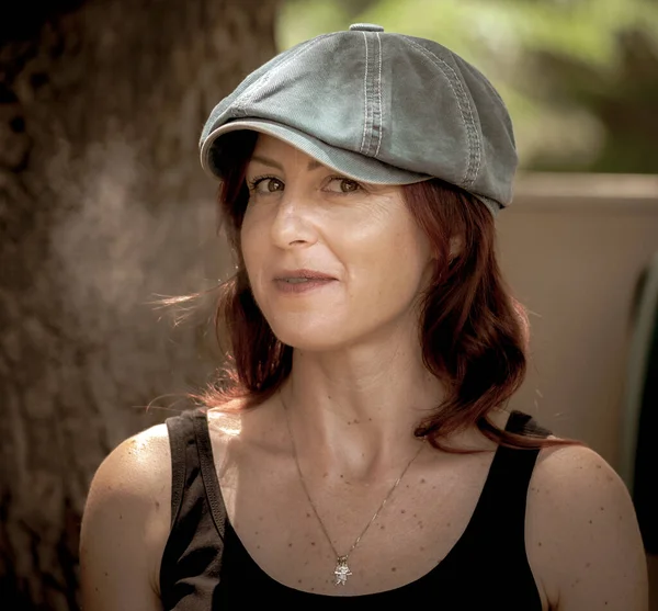 stock image Portrait of a young interesting woman in a cap posing at the camera