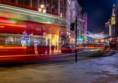 Londra, İngiltere - Aralık 2022: Piccadilly Sirki, arabalar, otobüsler ve sokakta yürüyen insanlar etrafındaki sokaklarda festival dekorasyonları ve Noel ışıkları