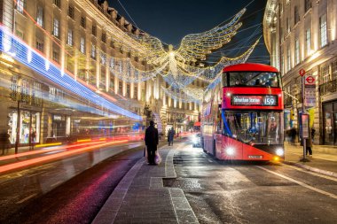 Londra, İngiltere - Aralık 2022: Piccadilly Sirki, arabalar, otobüsler ve sokakta yürüyen insanlar etrafındaki sokaklarda festival dekorasyonları ve Noel ışıkları