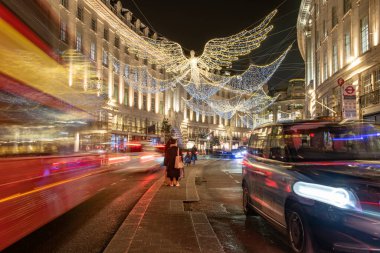 Londra, İngiltere - Aralık 2022: Piccadilly Sirki, arabalar, otobüsler ve sokakta yürüyen insanlar etrafındaki sokaklarda festival dekorasyonları ve Noel ışıkları