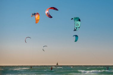 Uçurtma. Erkek bir sörfçü güzel bir Akdeniz dalgaları zemininde sörf yapar ve her türlü gösteriyi sergiler. Spor, sağlık, eğlence kavramı. İsrail Ashkelon Aralık 2021