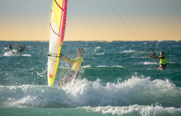 stock image Kitesurfing. A male surfer rides on a beautiful backdrop of Mediterranean waves and performs all kinds of stunts. The concept of sports, health, recreation. Israel Ashkelon December 2021