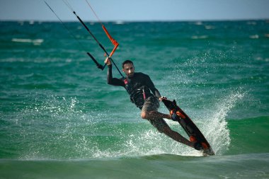 Uçurtma. Sörfçüler Akdeniz 'in dalgalarında çeşitli numaralar yaparak sörf yaparlar. İsrail Ashkelon 16 Ağustos 2023
