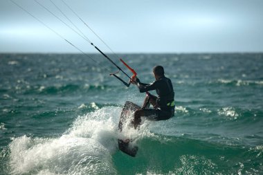 Uçurtma. Sörfçüler Akdeniz 'in dalgalarında çeşitli numaralar yaparak sörf yaparlar. İsrail Ashkelon 16 Ağustos 2023