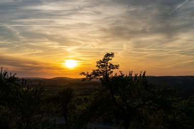 Tarlaları, tepeleri ve altın ışıklarıyla gün batımı ve manzara