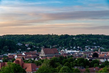 Arkasında yeşil tepeler olan Schwaebisch Gmuend adında bir Alman kasabasının manzarası