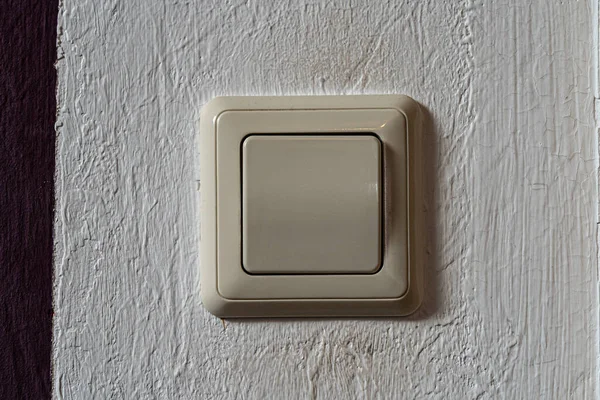 Light switch on the white wall to turn on the light