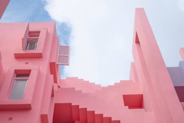 Calpe 'deki ikonik Muralla Roja binasında yaşayan İspanyol sahillerinde geometrik şekilli ve pastel renkli bir kadın.