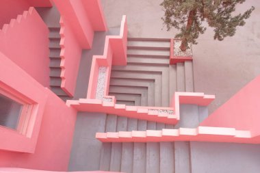 İkonik Muralla Roja binası avlusu ve pembe renkli yaratıcı merdivenleri var.