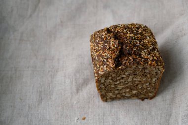 Kenevir masa örtüsü üzerinde çok tahıllı siyah ekmek. Boşluğu kopyala.