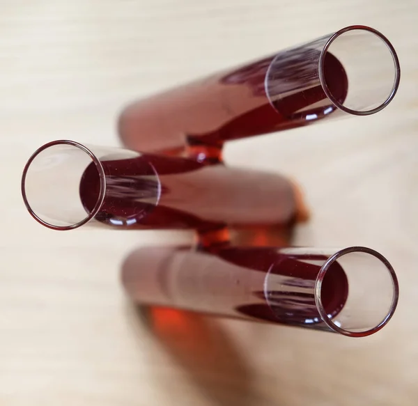 Three test tubes of red wine. Top view.