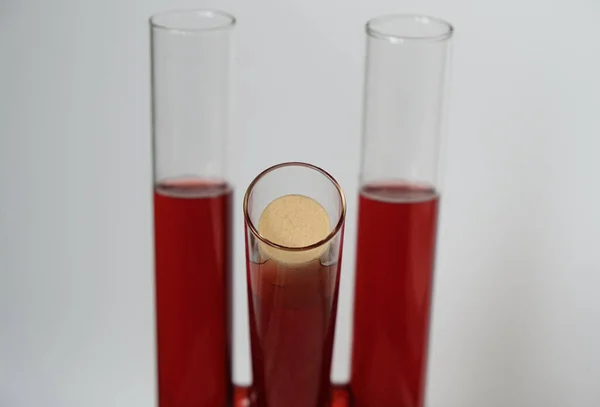 Three test tubes of red wine. Artificial wine cork.