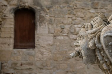 18 Mart 2023. Pernes-les-Fontaines, Provence-Alpes-Cte d 'Azur, Fransa. Eski ortaçağ duvarının arka planında antik taş içme pompa odası.