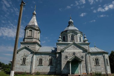 09 Temmuz 2023. Yaroslavychi, Rivne bölgesi, Ukrayna. Ukrayna 'daki eski ahşap kilise. Duvardaki yazıt kutsanmış olan Tanrı 'nın adıyla gelen..