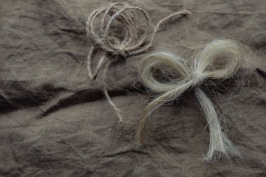 Flax Knots veya Fiyonk. Keten kumaş arka plan. Boşluğu kopyala.