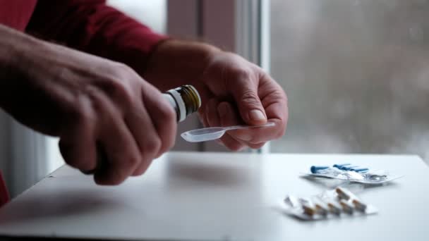 薬を測定スプーンに注入する 人が咳シロップを取る — ストック動画