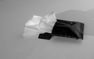 Individual refreshing Wet wipe. Disposable Wet napkins for restaurants. Black packaging. clipart