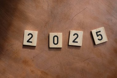 Bakır zemin üzerinde 2025 yazı olan tahta küpleri. 2025 Yeni Yıl arkaplanı kavramı.