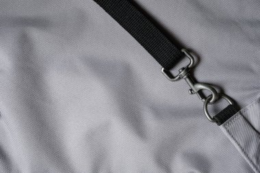 Dayanıklı Gri Metal Döndürme Kancası. Sırt çantası için taktik karabina. Swivel Tokaları. Kara ağ. Gri arka plan. Boşluğu kopyala.