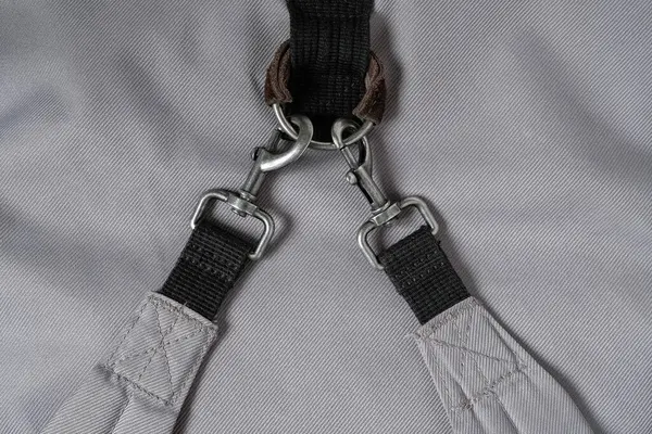 stock image Two durable swivel snap hooks are hooked to a metal ring. Tactical carabiners for backpack. Swivel clasps. Black webbing. Gray background.