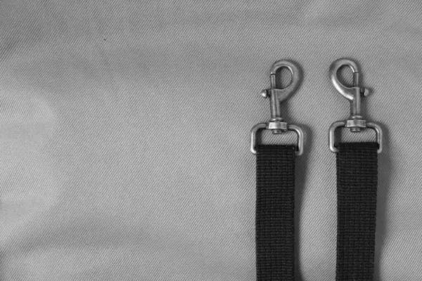 stock image Durable Metal Swivel Snap Hooks. Tactical Carabiner for Backpack. Swivel Clasps. Black webbing. Gray background. Copy space.