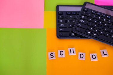 The word School on a bright colorful background. Two keyboards. Modern school concept. Distance and mixed learning. Copy space. clipart