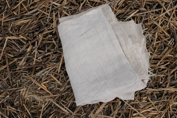 stock image Folded hemp fabric. Textures of cloth and dry reed stems. Ecological concept. Sustainable lifestyle.