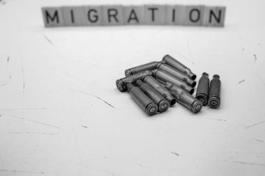 Minimalist Migration Concept with Bullet Casings. Escape from War. Conflict and Reflection. Copy Space. Black and White. Shallow Depth of Field. clipart