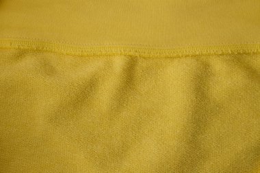 Pamuk elastik kumaşın içi dışına çıkmış. Ray Flower veya Parlak Sarı Renk. Doğal pamuk liflerini sentetik elastik liflerle harmanlamak. Sarı kumaş arkaplanı.