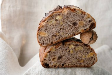 Kenevir masa örtüsü üzerinde cevizli, kuru üzümlü ekmek. Ekmek ve ceviz piramidi. Uzayı kopyala Sığ alan derinliği.