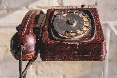 Eski koyu kırmızı telefon. Çevirmeli arama. Kablo..