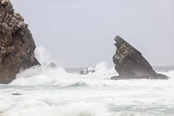 stock image An up close detailed look at powerful waves crashing on the large rocks of Portugal's beautiful coastline.