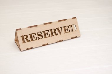 Ahşap tabela ve beyaz ahşap bir masa ayırtılmış.