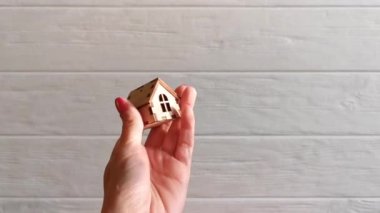Bir el, ahşap bir evi, kendi evini satın alma ya da kiralama konseptine aktarır.