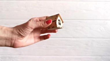 Bir el, ahşap bir evi, kendi evini satın alma ya da kiralama konseptine aktarır.