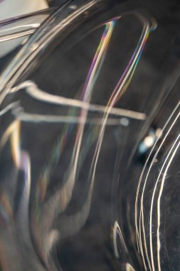 Yanardöner ışık ve gökkuşağı ile kaplı plastik kaplı yüzeyin soyut fotoğrafı