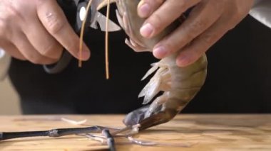 Şef dev nehir karideslerini çıplak elleriyle ve mutfak makasıyla oyuyor..