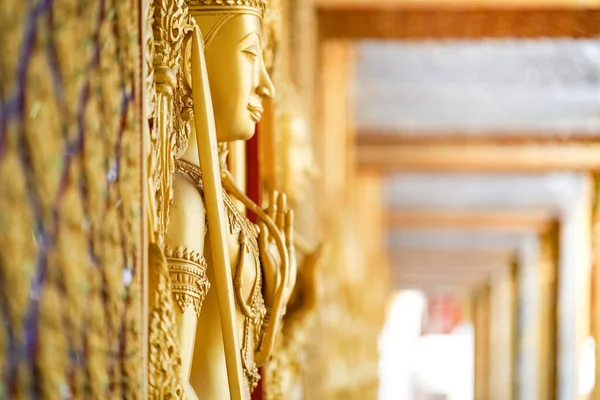 Gold door angel sculpture is a high relief art and is made of resin at the Golden Castle, Tha Sung Temple, Uthai Thani