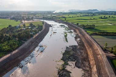 İnşaat, yağmur mevsiminde sel baskınını önlemek için bir kanal ve baraj kazıyor. Tarih 14 Mayıs 2021, Uthai Thani, Tayland.