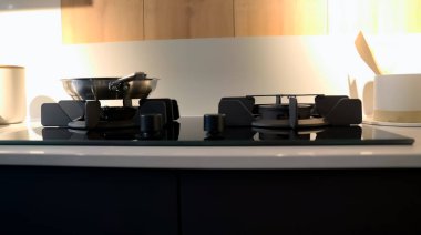 Mutfağın içinde, üzerinde tava olan bir gaz ocağı yemek pişirmek için kullanılıyor..