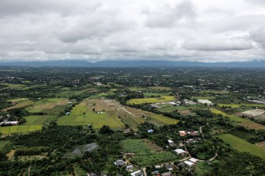 yüksek bir perspektiften bakıldığında. Tayland 'ın Lamphun Eyaleti' ndeki Pa Sang Bölgesi 'ndeki gökyüzü bulutları ve yeşil çimen ağaçları arasındaki zıtlığa dikkat edin..