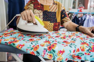 Öğrenci eteği ve kıyafetlerini bir evde ütüleyen yaşlılar..