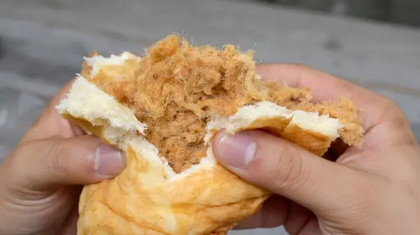 stock image Watch as the man expertly holds and shreds a fluffy bun, revealing the juicy, succulent shredded pork hidden within. The smell of the freshly cooked pork wafts through the air