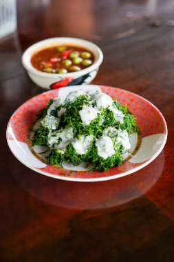 Bai Chakram with coconut cream served with Nam Prik Kapi or Thai shrimp paste chili sauce in the local restaurant. A famous healthy menu in Tambon Yi san, Samut Songkhram. clipart