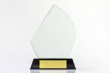 Beyaz zemin üzerinde boş şeffaf cam ödül kupası, şeffaf kristal ödülün özel lazer kesimi.  