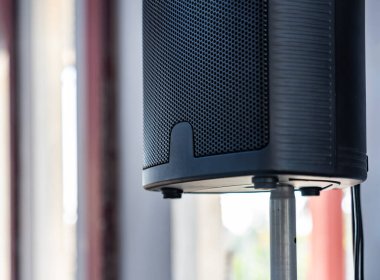 Modern siyahi konuşmacının yakın plan fotoğrafı ve bulanık arka plandaki metalik duruş..