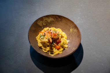 Spaghetti Carbonara Makarnalı Yumurta ve Peynirli Krem Krem Soslu Karides ve mikro otlu Stüdyo ışığı altında Dünya Çemberi kâsesinin tepesinde.
